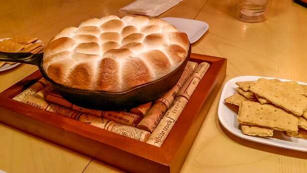 Food 2015 Smores: chocolate morsels in bottom of iron skillet, coved with marshmallows, browned in the oven, served with graham crackers